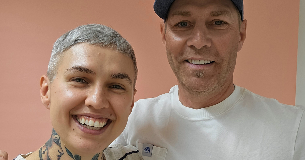 Mies ja nainen poseeraavat poscast-studiossa ja hymyilevät kameralle